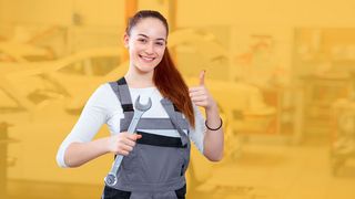 Praktikumsprämie Junge Frau in Werkstatt-Arbeitskleidung mit Schraubenschlüssel