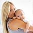 Mutter hält ihr Baby auf dem Arm und lächelt