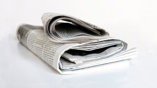Pressemeldungen der IKK gesund plus Zeitungsstapel auf einem Tisch