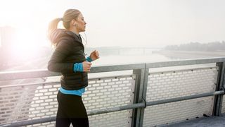Junge Frau beim Joggen über eine Brücke