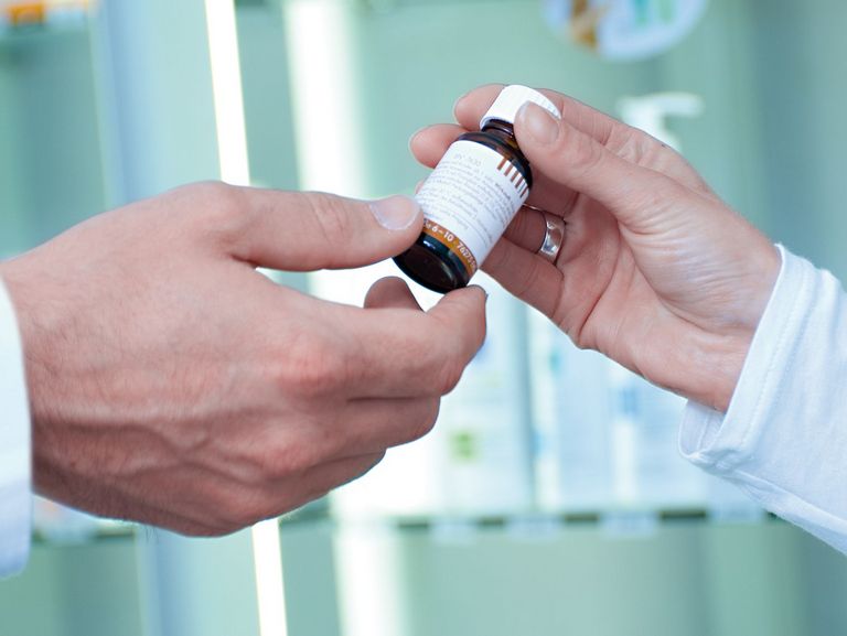 Apothekerin reicht Arzt Medikament