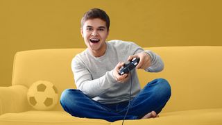 Teenager spielt mit einer Spielekonsole auf dem Sofa