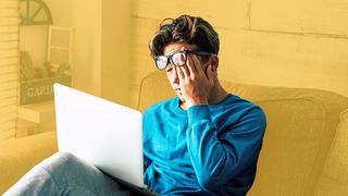 Jugendlicher auf der Couch mit Laptop und Schwindelgefühl