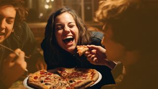 Teenager genießen laut lachend eine gesund Pizza