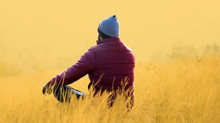 Achtsamkeit Mann sitzt im Lotussitz auf einer herbstlichen Wiese