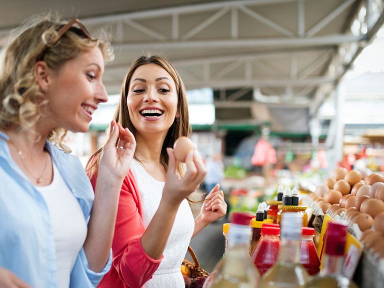 Zwei Frauen kaufen auf einem Biomarkt Lebensmittel