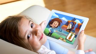 Digitales Training für Kinder mit Artilulationsstörungen Mädchen sitzt auf der Couch mit einem Tablet in der Hand