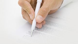 Kurarztvertrag Mann unterschreibt ein Dokument