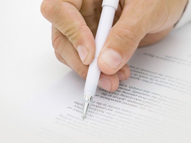 Mann unterschreibt ein Dokument