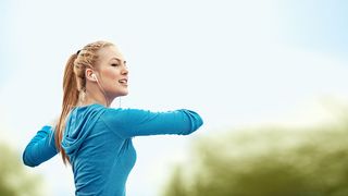 Blonde Frau mit einer türkisfarbenen Jacke bei ihrem Feierabend-Workout