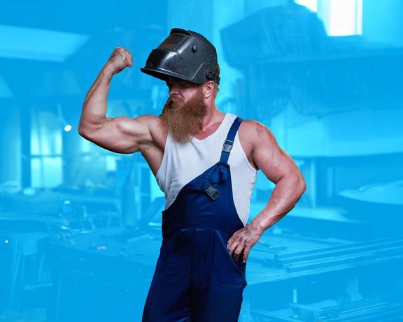 Muskelpaket Muskelprotz in Handwerkerkleidung zeigt mit einem Arm seine Muskeln