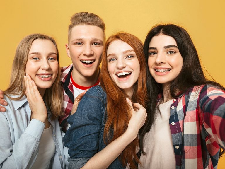 Vier Jugendliche schauen fröhlich in die Selfiekamera