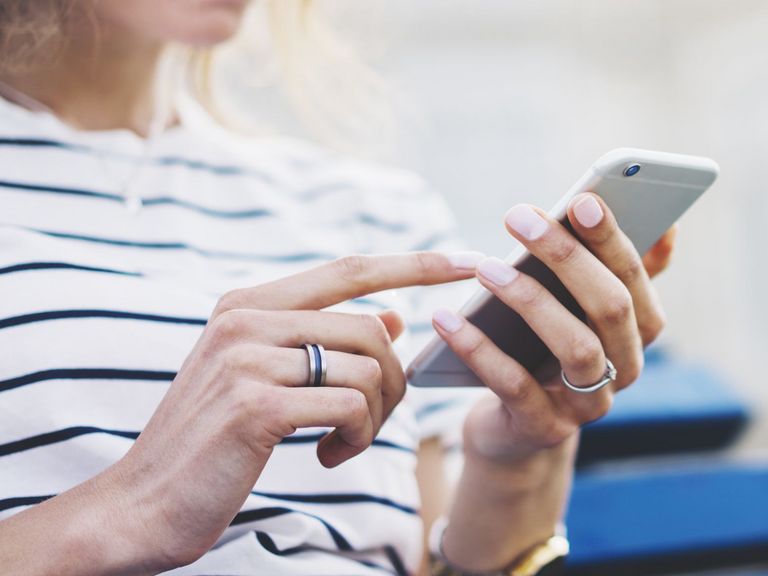 Frau schaut auf ihr Smartphone in der Hand