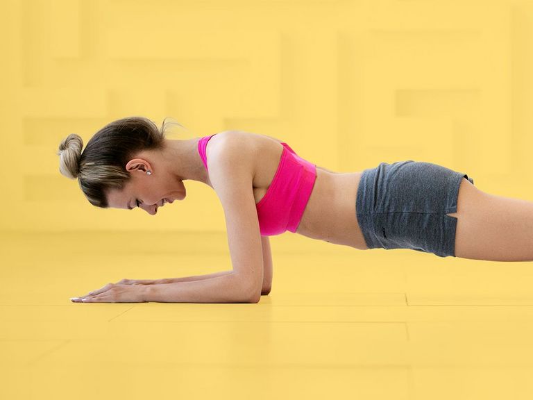Junge Frau im Sportdress in der Unterarmliegestütze
