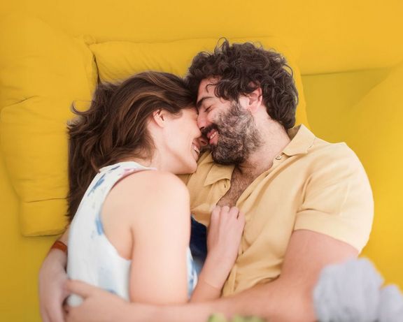 Bauchgefühlpaket Mann und Frau eng aneinander gekuschelt im Bett