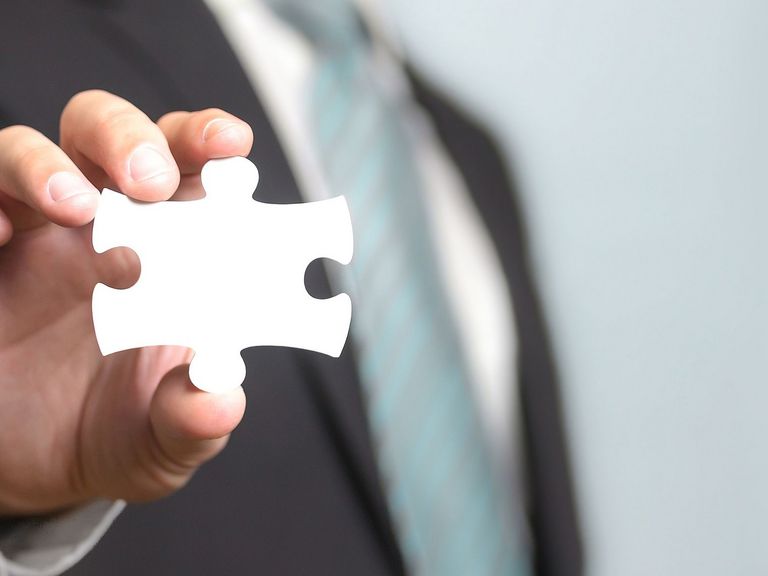Mann hält ein Puzzleteil