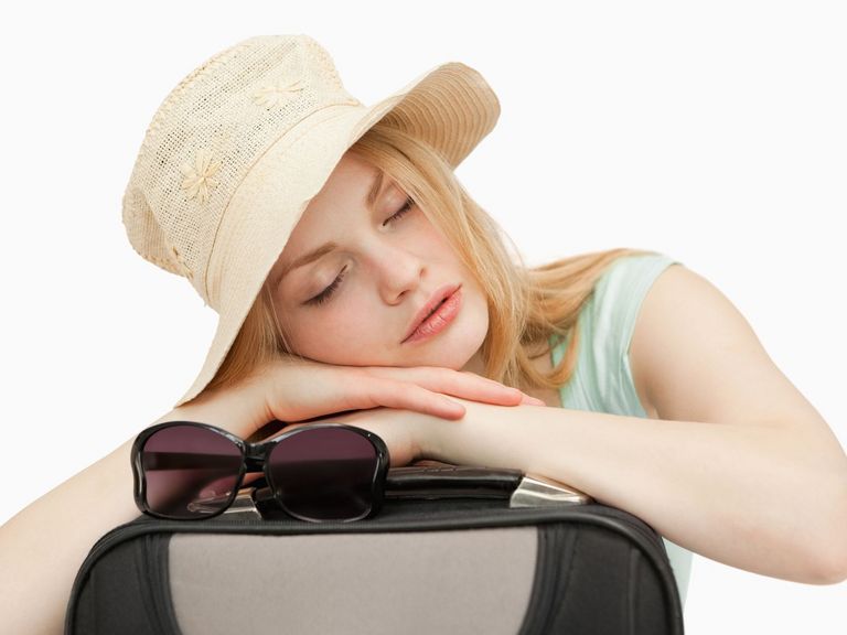 Frau hat Jetlag und schläft auf auf Koffer