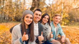 Herbsttipps Jugendliche in herbstlicher Kleidung mit Daumen hoch