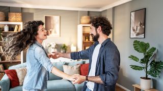 Pärchen tanzt fröhlich im Wohnzimmer