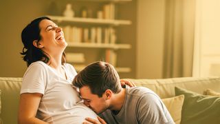 Bauchgefühlpaket Mann küsst den Babybauch einer lachenden Frau