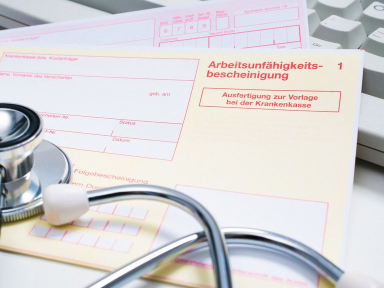 Krankenschein auf einem Arzt-Schreibtisch