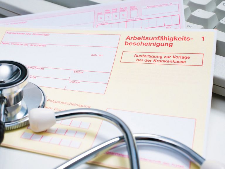 Krankenschein auf einem Arzt-Schreibtisch