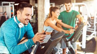Mann im Sportdress sucht sich für sein Training die richtige Musik auf seinem Smartphone aus