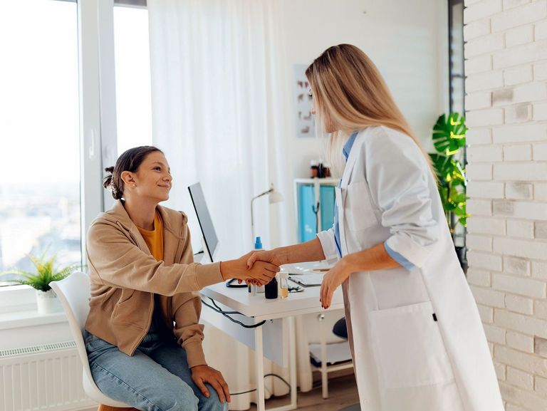Ärztin begrüßt ein Mädchen zum Beratungsgespräch