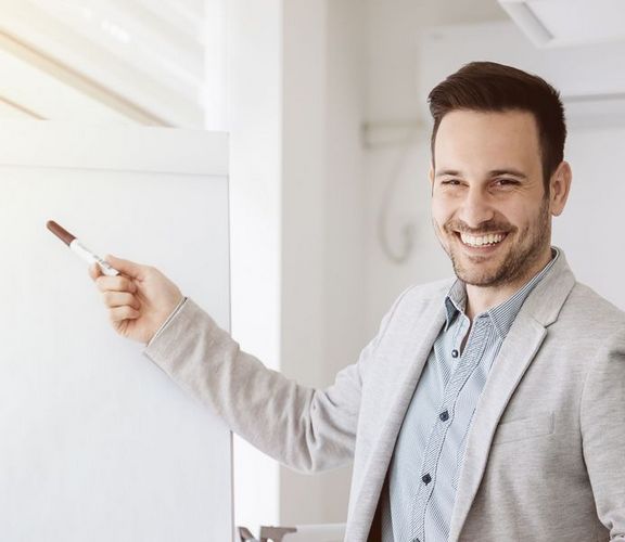 IKK-Jahreswechselseminare Ein Büro-Mitarbeiter präsentiert etwas vor einem Flipchart