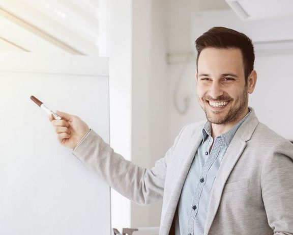 Ein Büro-Mitarbeiter präsentiert etwas vor einem Flipchart