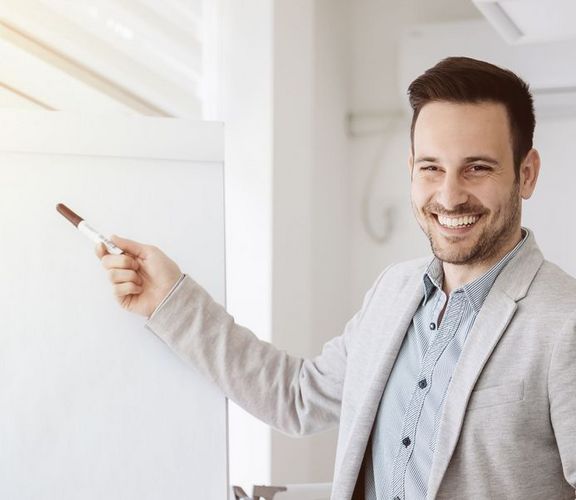 Ein Büro-Mitarbeiter präsentiert etwas vor einem Flipchart