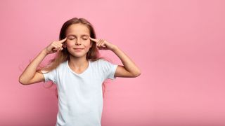 Mind-Factory Mädchen schließt die Augen und legt die Zeigefinger an die Schläfen