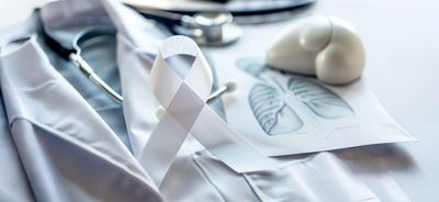 Arztkittel, Stethoskop und Bild einer Lunge auf einem Tisch