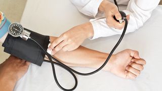 Bluthochdruck Arzt misst Blutdruck bei Patientin