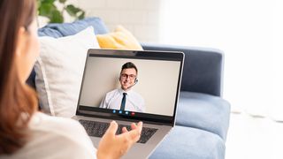 Videoberatung Frau sitzt auf dem heimischen Sofa und hat einen Videocall mit der Serviceberatung