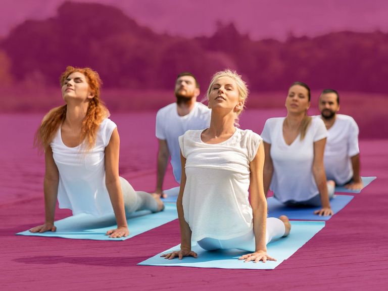 Gruppe Yoga-Sportler auf einem Steg am See
