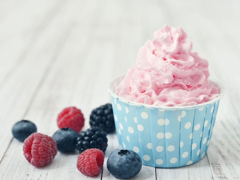 Frozen Joghurt in einem Pappbecher und dazu Beeren