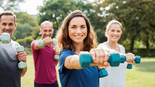 Gruppe im Paar in sportlicher Kleidung und kleinen Hanteln