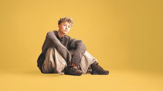 Jugendlicher im Schlabberlook sitzt lässig auf dem Boden