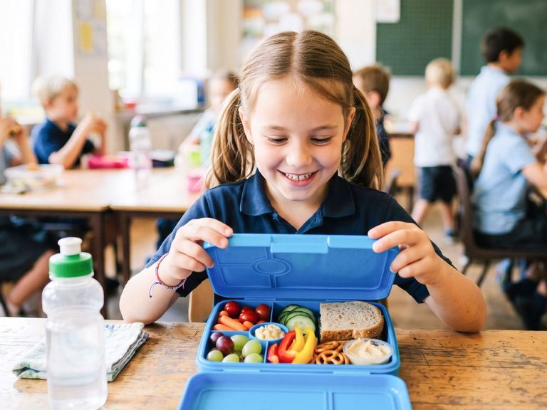 Schülerin zeigt ihre gut gefüllte Brotdose