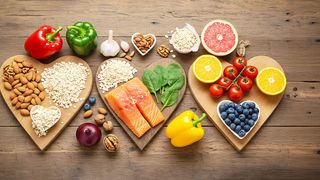 Holztisch mit herzförmigen und gesund gefüllten Tellern