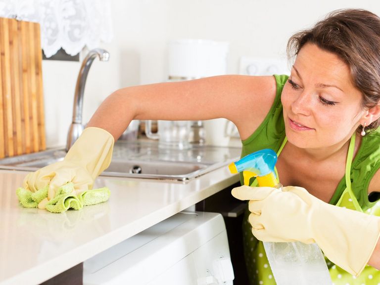 Frau putzt die Arbeitsfläche in der Küche
