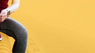 Gesunder Körper Sportlerin bindet sich auf einer Bank die Schuhe zu