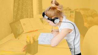 Online-Nachhilfe Schülerin am Schreibtisch mit einem Tablet und Kopfhörern