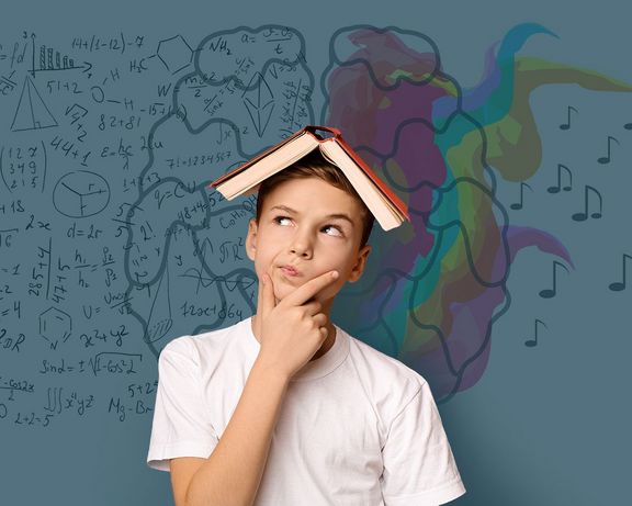 Junge mit offenem Buch auf dem Kopf und nachdenklicher Pose