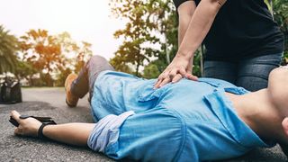 Wiederbelebung mit Herzdruckmassage bei einem Mann, der auf der Straße liegt