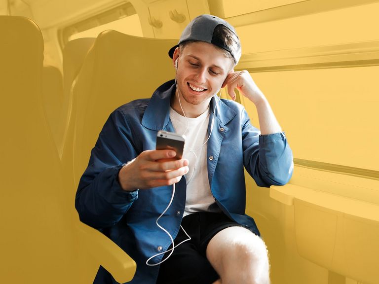 Azubi sitzt im Zug auf dem Weg zur Arbeit