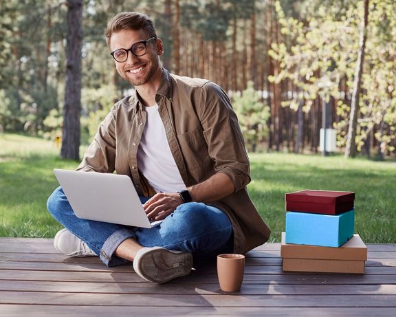 Für jeden das Richtige! Mann mit Laptop auf einer Holzterrasse im Wald