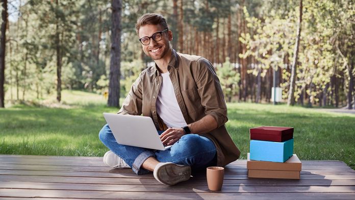 Für jeden das Richtige! Mann mit Laptop auf einer Holzterrasse im Wald