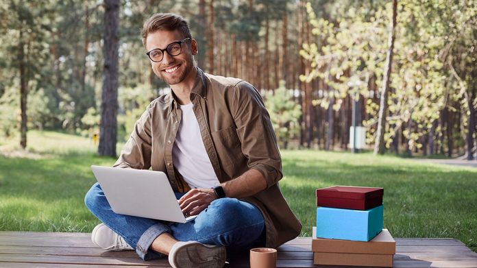 Für jeden das Richtige! Mann mit Laptop auf einer Holzterrasse im Wald